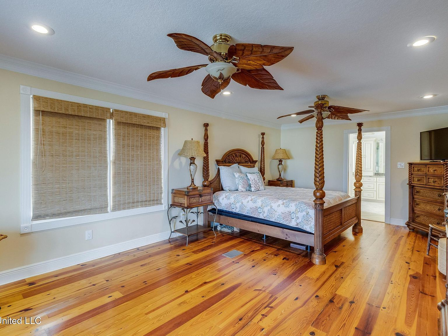 Primary bedroom with polished pine wood floors and en-suite bathroom