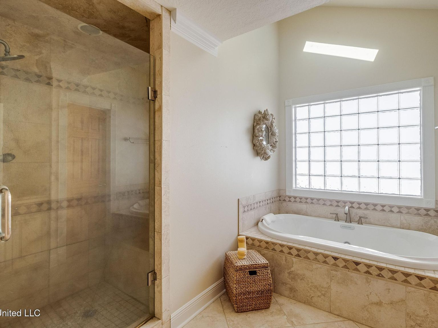 Primary bathroom with walk-in shower, soaking tub, and skylight