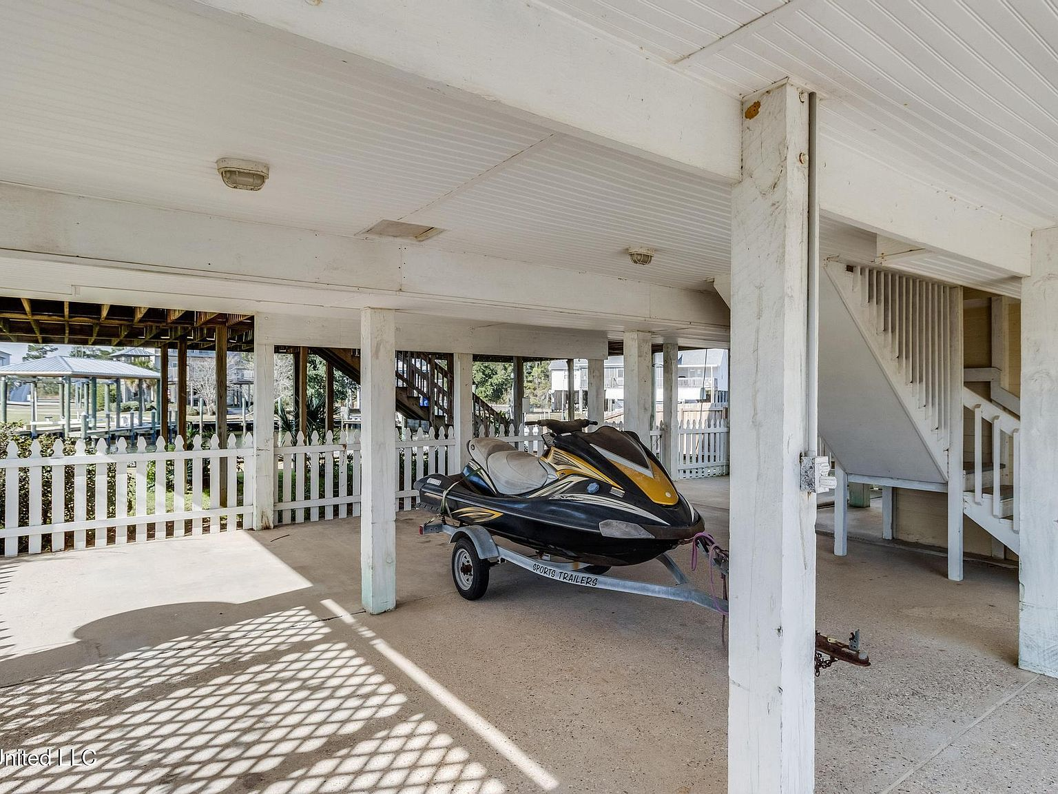 Covered ground-level carport and patio area beneath the elevated home
