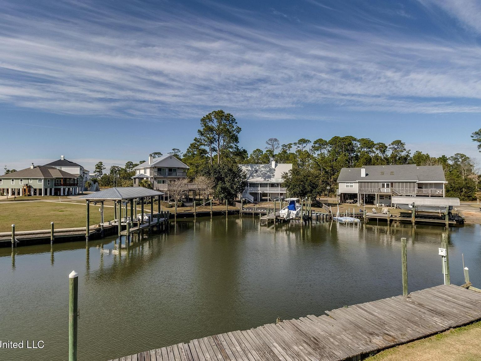Private dock on bulkheaded canal with neighboring homes across the waterway