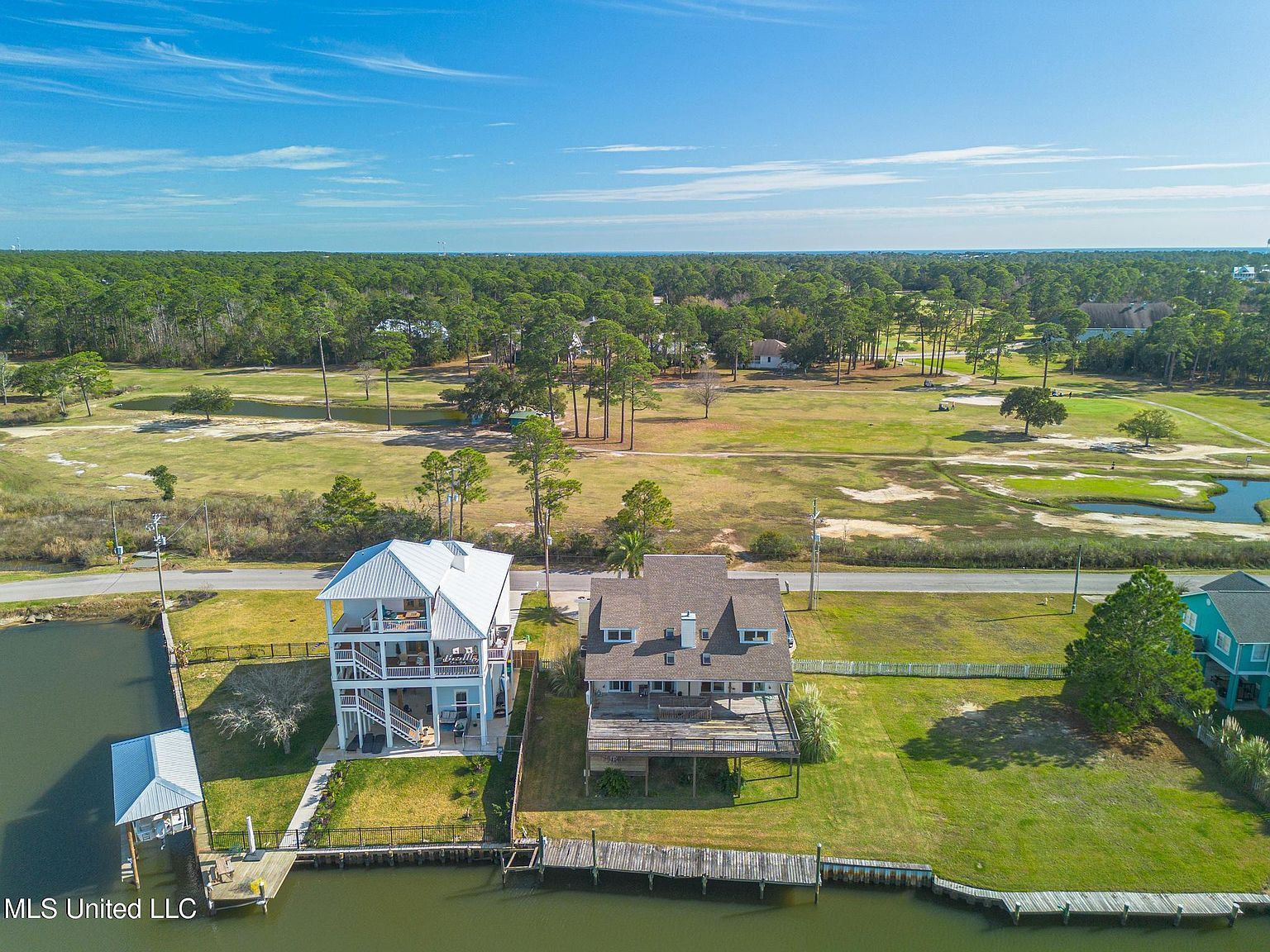 Aerial view of canal community with golf course across the street