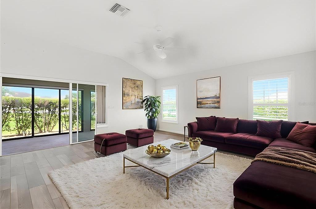 Living room with vaulted ceiling and sliding glass doors to patio