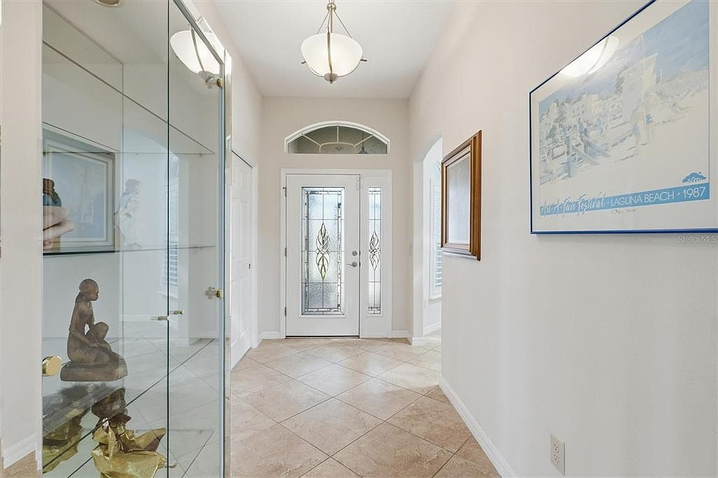 Entry foyer with stained glass front door, sidelight, and arched transom