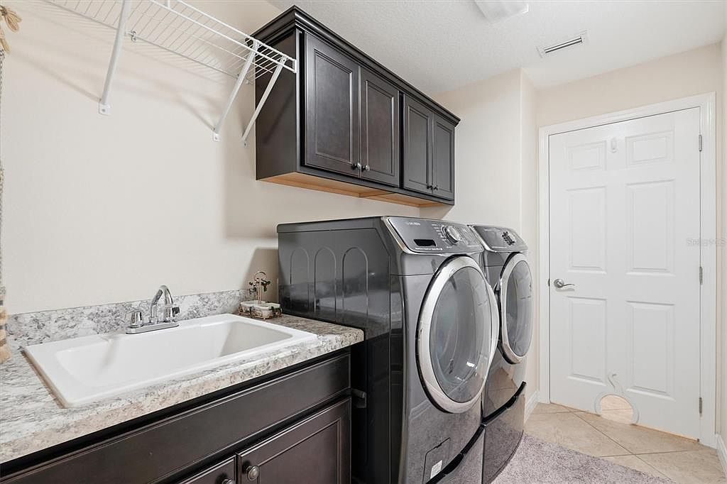 Laundry room with dark cabinetry