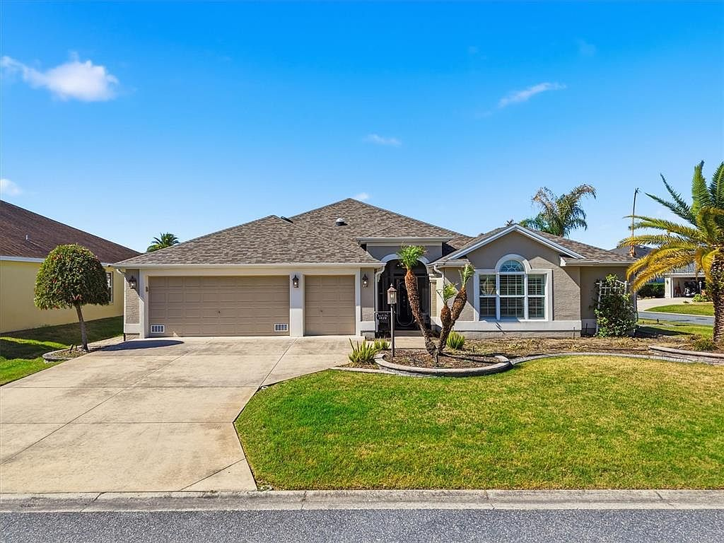 Street-level view of the Florida ranch home with two-car and golf cart garage