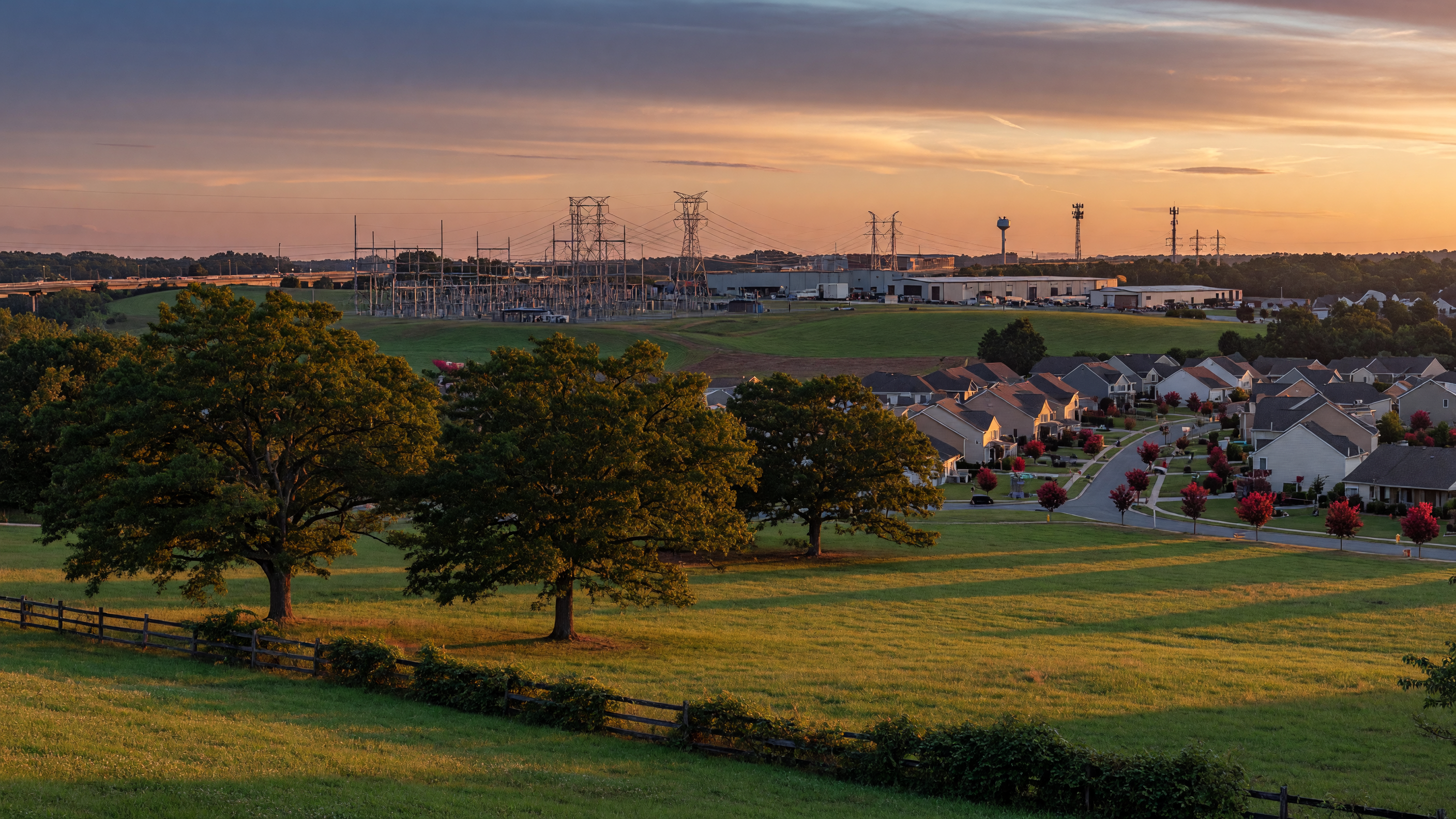 Wide landscape view of Spotsylvania County Virginia showing the tension between rural preservation and industrial development with residential communities and distant infrastructure along the I-95 corridor