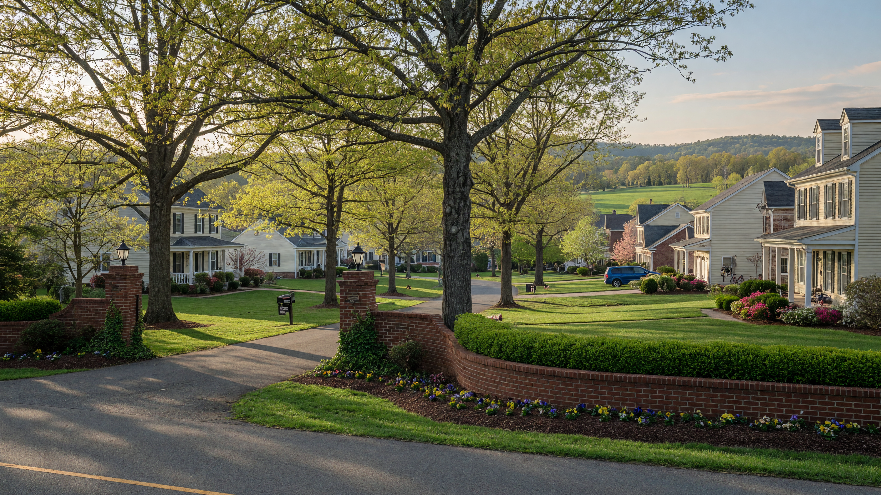 Breckenridge community entrance in Spotsylvania County Virginia — mature oak trees, manicured lawns, and colonial-style single-family homes on rolling Virginia piedmont hills