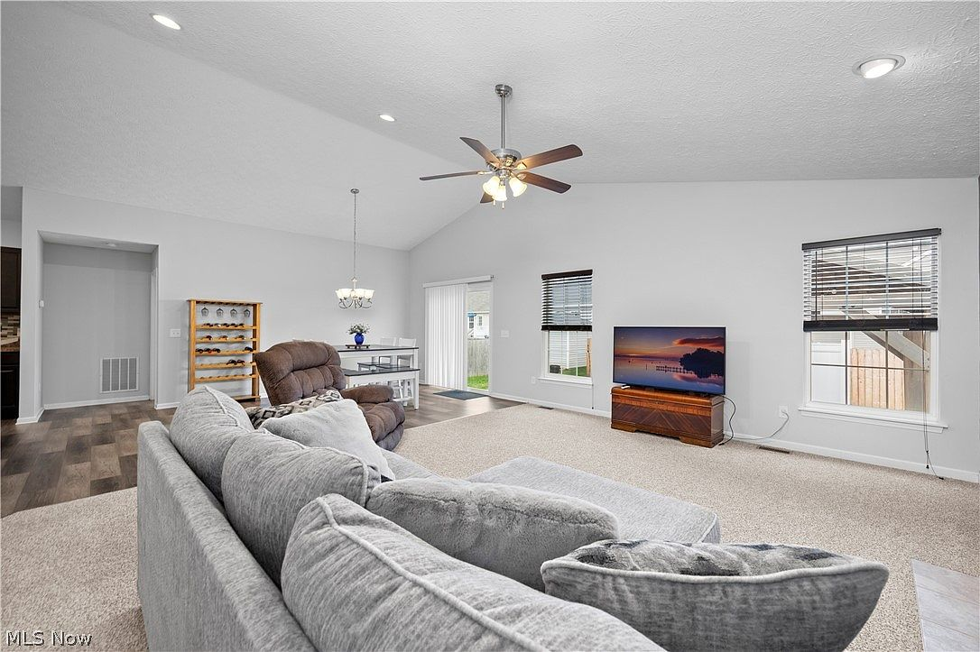 Open-concept living and dining area with vaulted ceilings and natural light