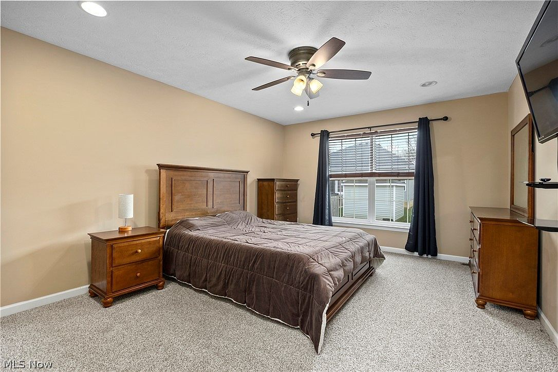 Master bedroom with wooden furniture and ceiling fan