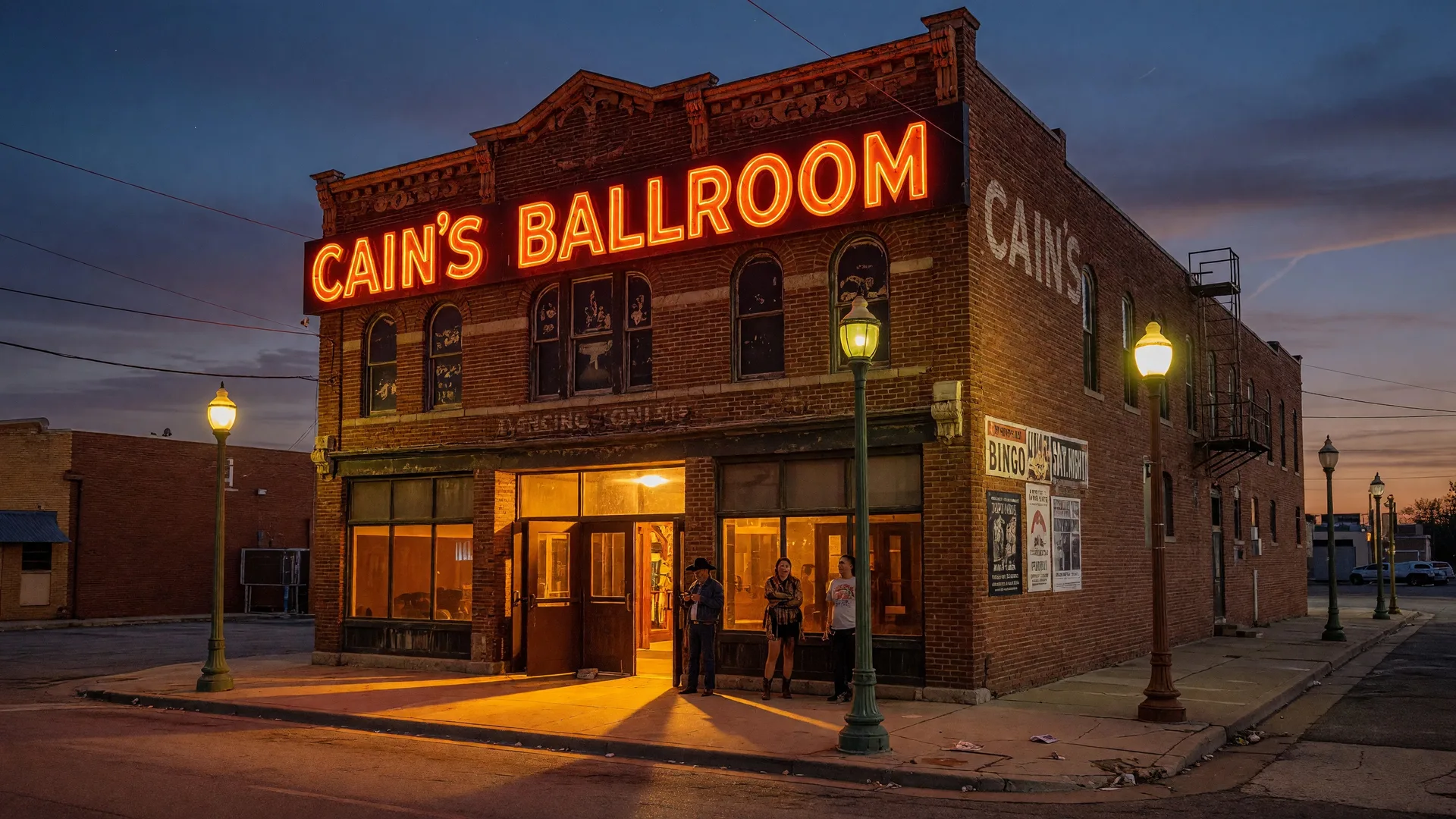 Cain's Ballroom in downtown Tulsa at dusk with its iconic glowing neon sign against a twilight blue sky