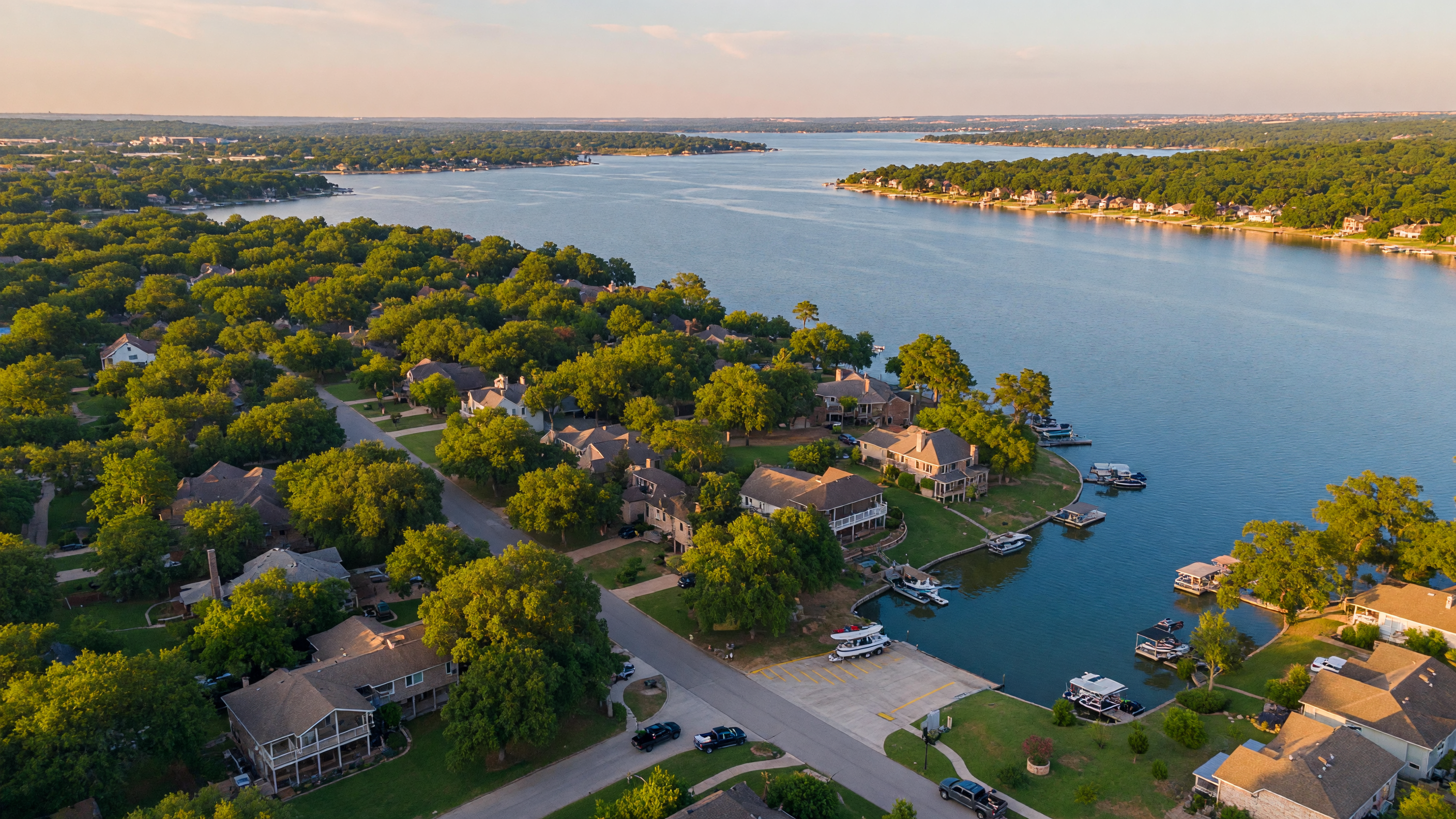 Aerial view of Hickory Creek, Texas showing mature tree canopy, lakeside neighborhoods, and Lake Lewisville shoreline on a clear afternoon