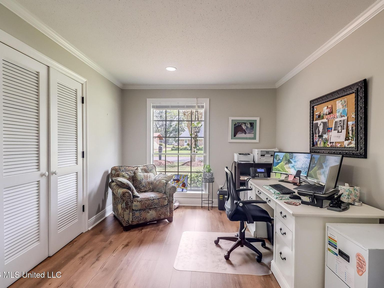 Bedroom repurposed as a home office with desk and dual monitors