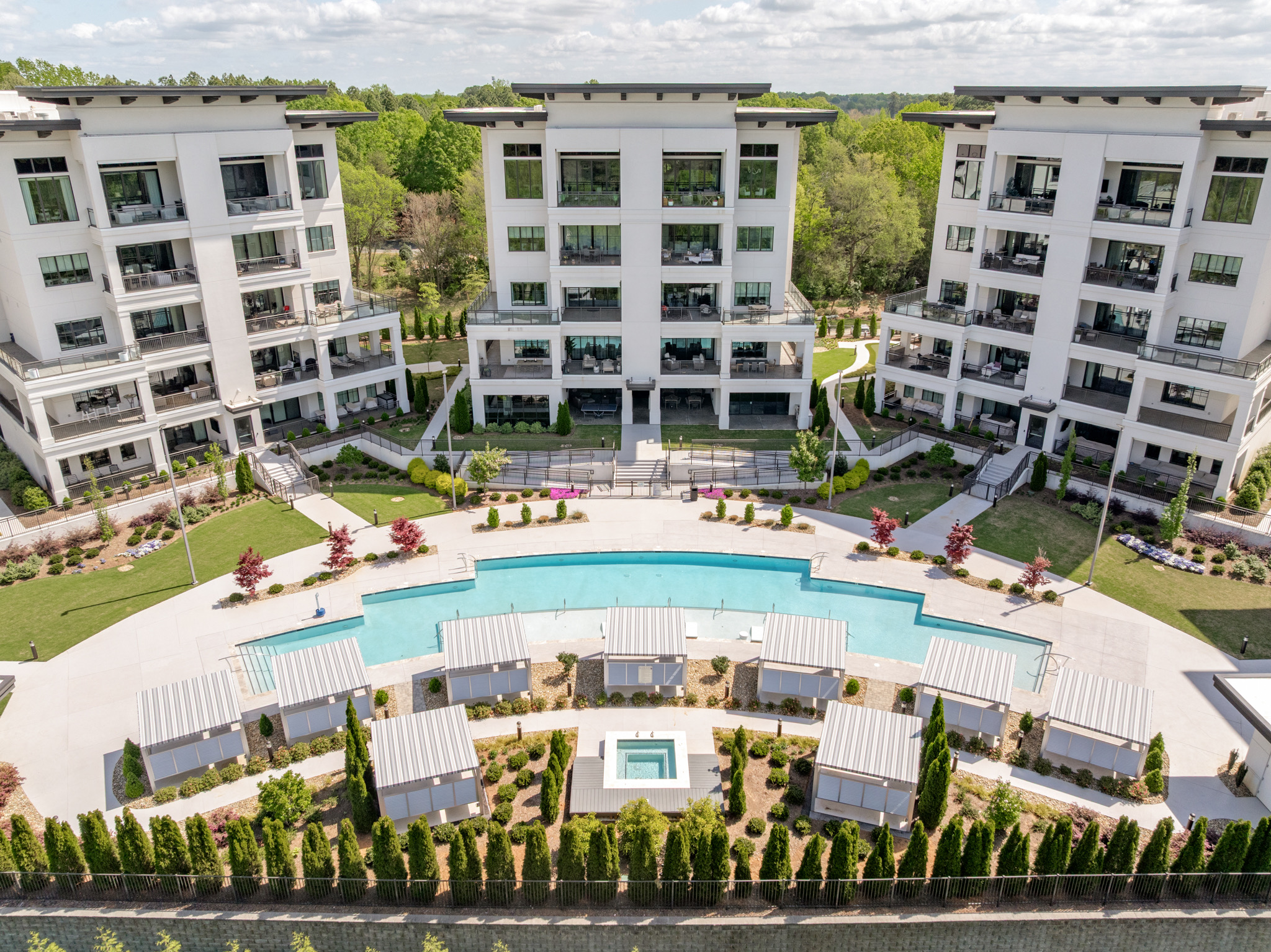 Drone aerial of the luxury condominium complex with curved pool and spa