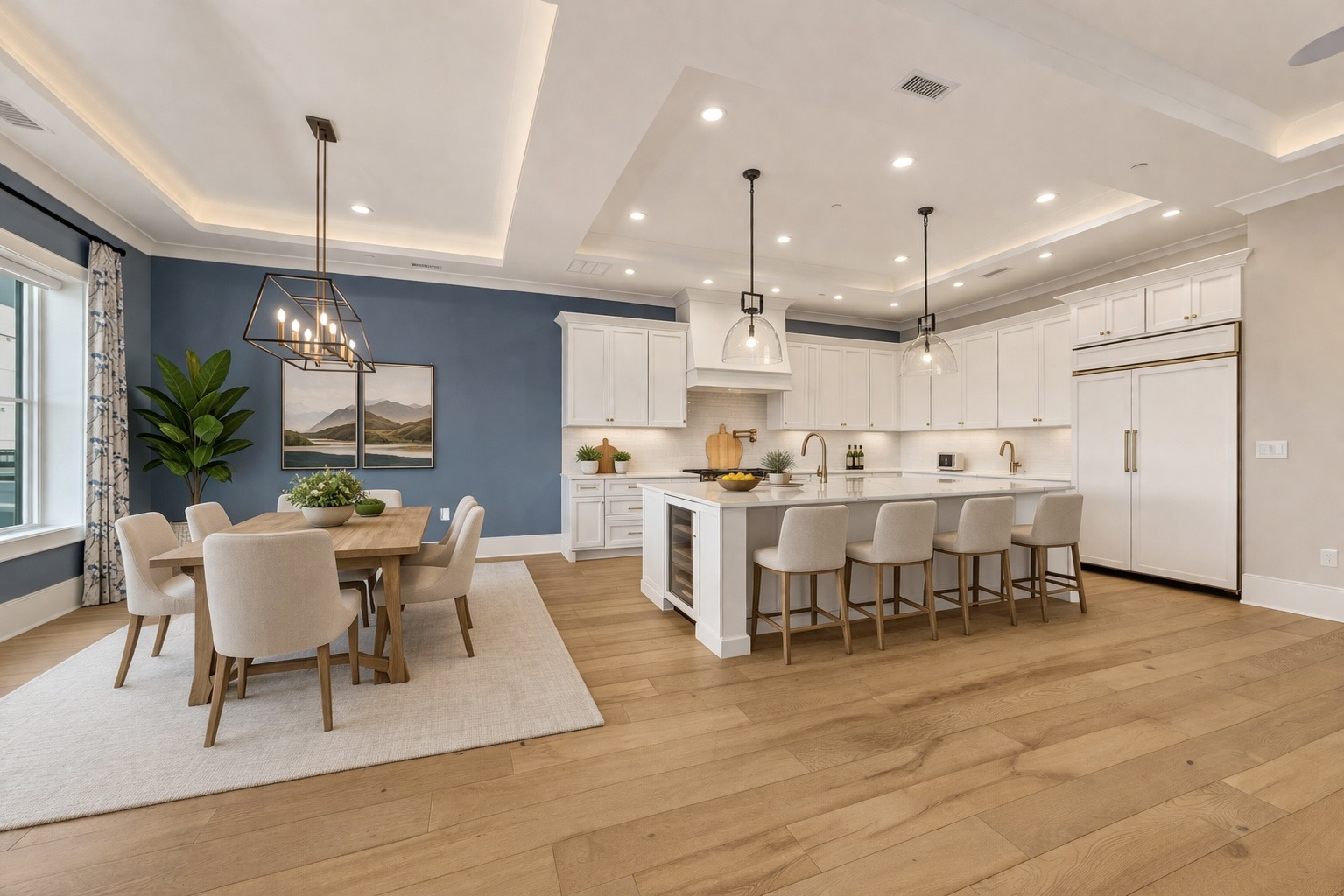 Open-concept kitchen with white shaker cabinetry, custom range hood, and dining area
