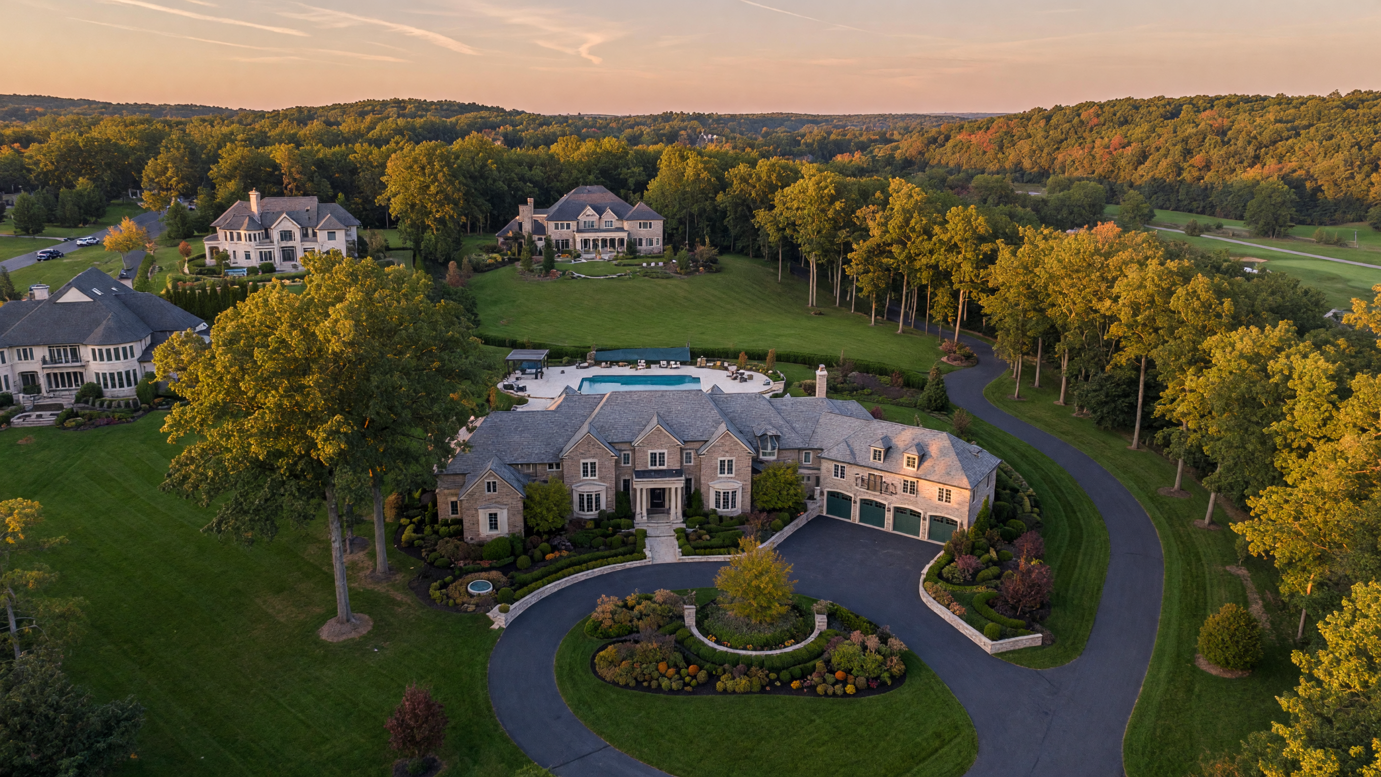 Aerial view of a luxury estate home in a prestigious Mid-Michigan neighborhood with manicured landscaping and mature trees