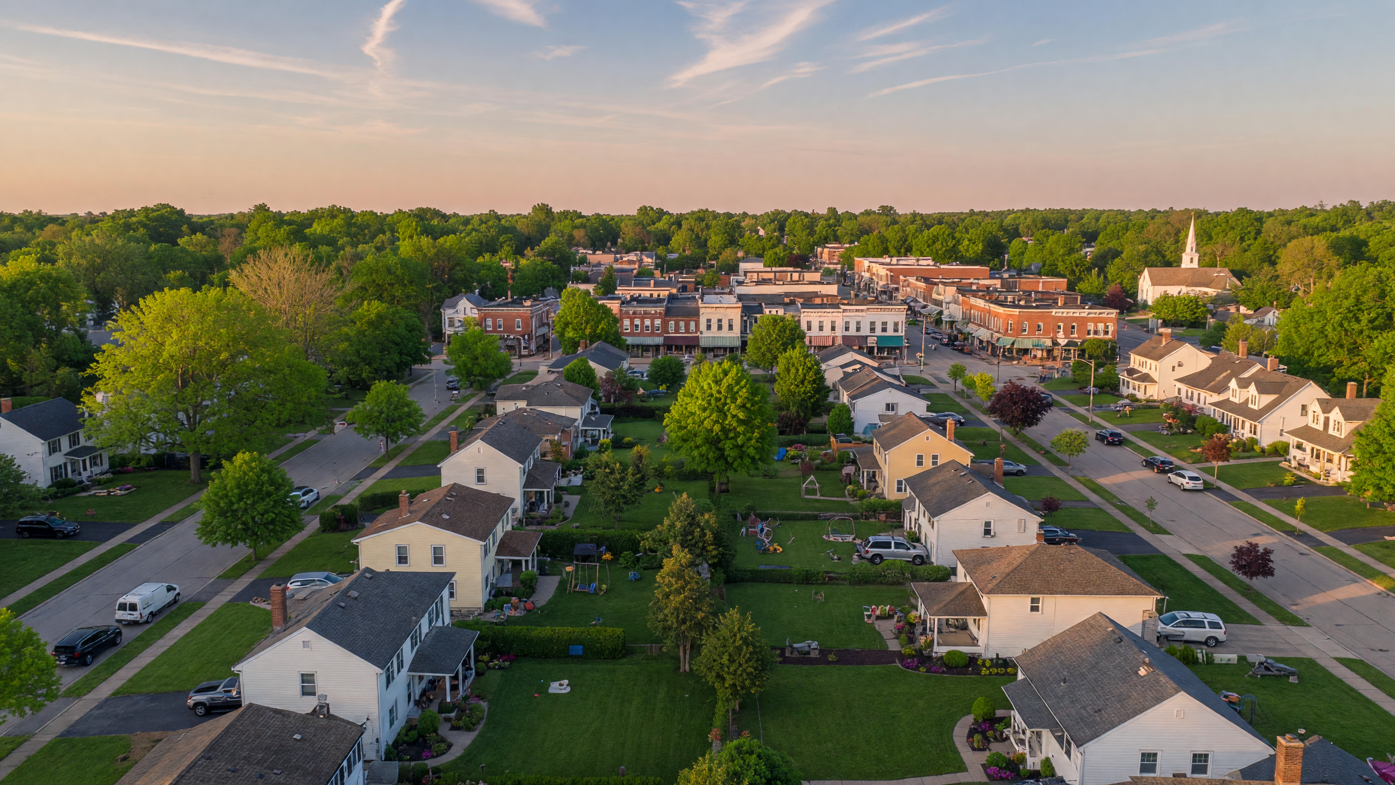 Aerial view of a welcoming Mid-Michigan suburban neighborhood with tree-lined streets and family homes