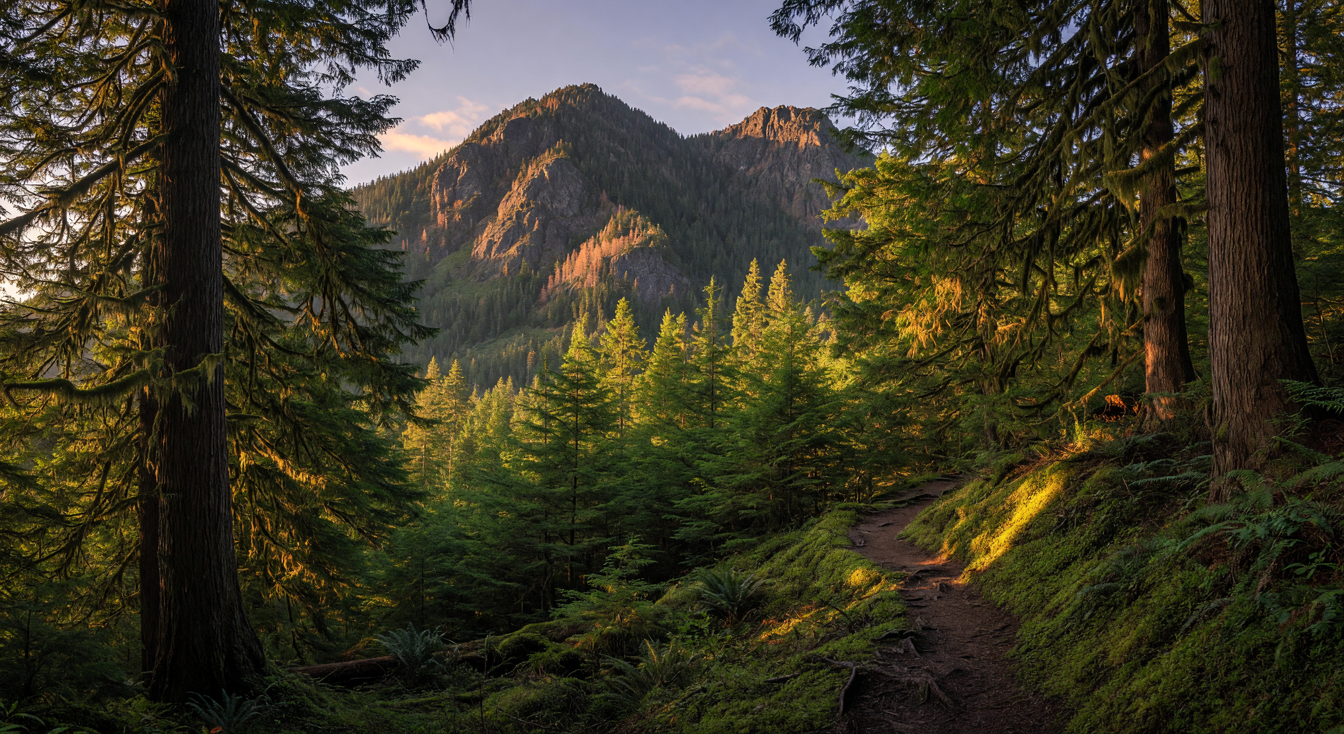 Langford Lake surrounded by forested mountains and new residential communities at golden hour, Westshore, British Columbia