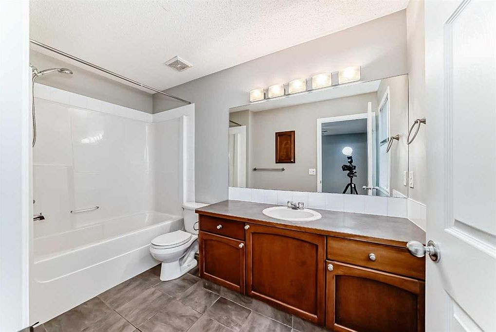 Full bathroom with tub/shower and wood vanity