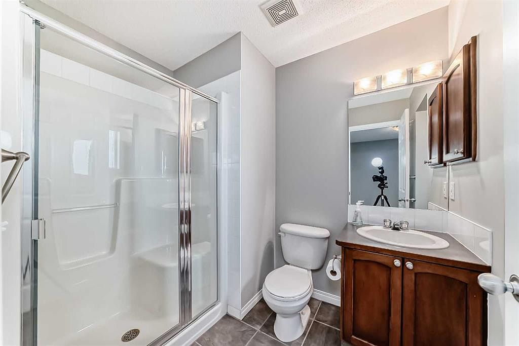 Ensuite bathroom with walk-in shower and dark wood vanity