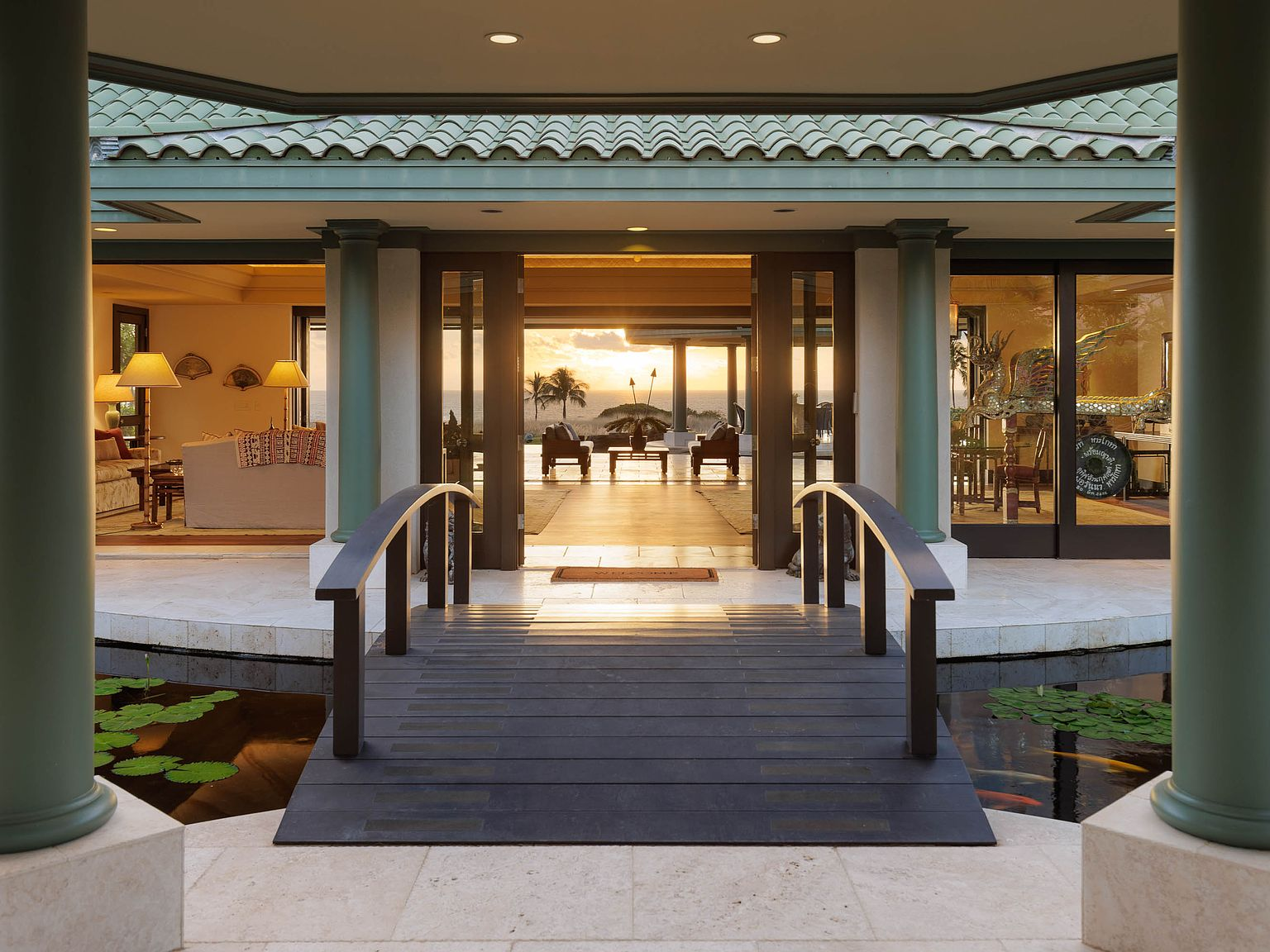 Dramatic bridge entrance over koi pond leading to the main hale