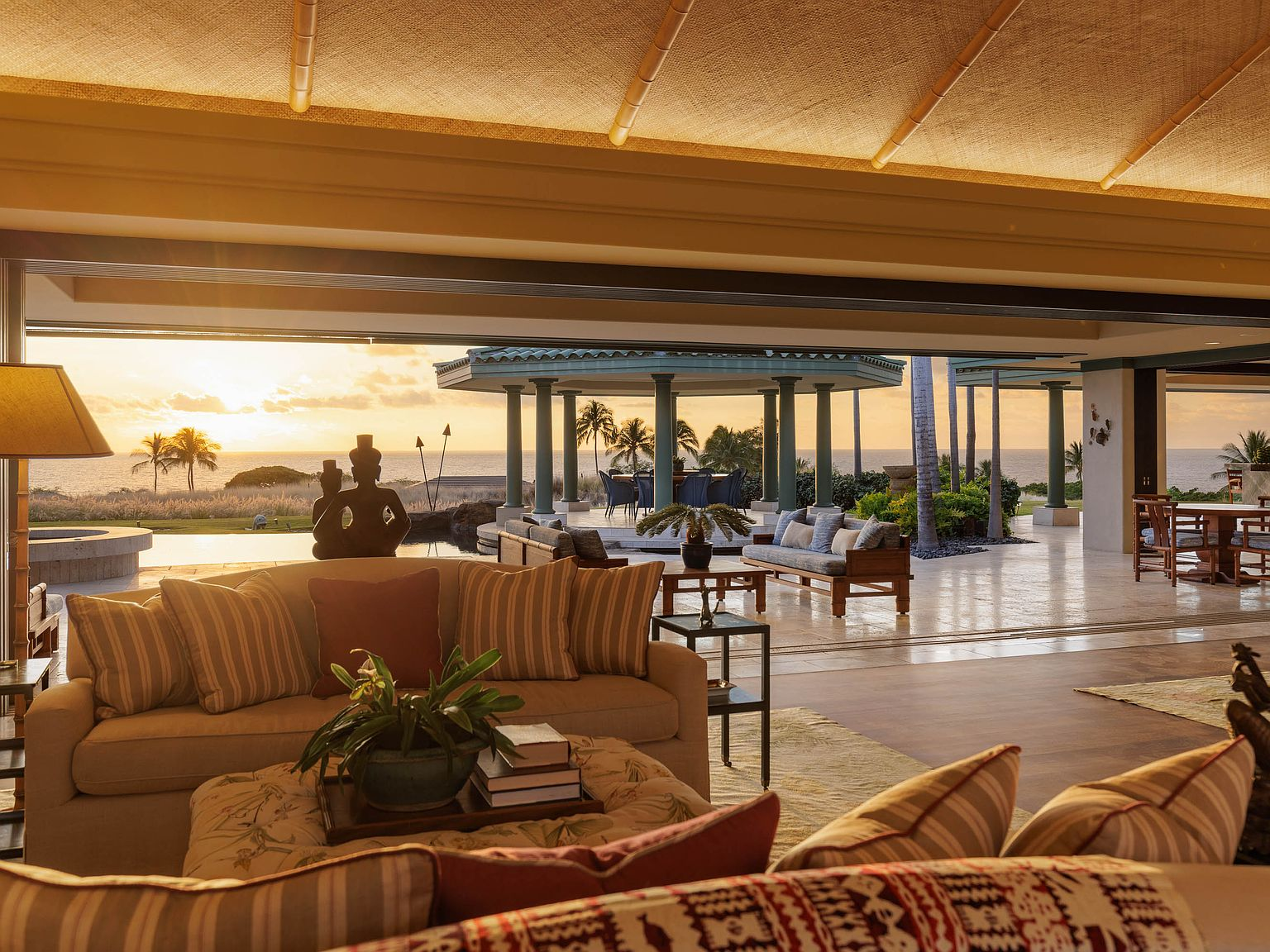 Great Room looking out through open pocket doors to lanai and sunset ocean view