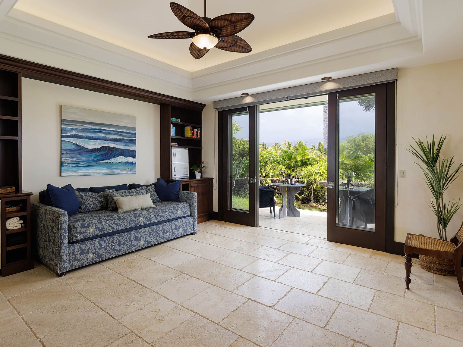 Guest pavilion living room with travertine floors, dark wood cabinetry, sliding glass doors