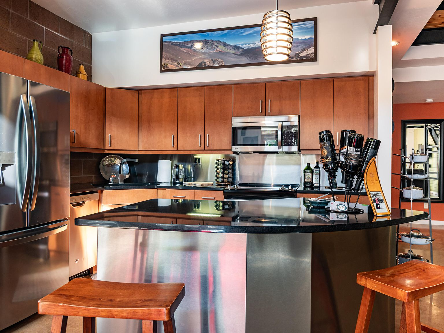 Kitchen with wood cabinets, black countertops, and breakfast bar