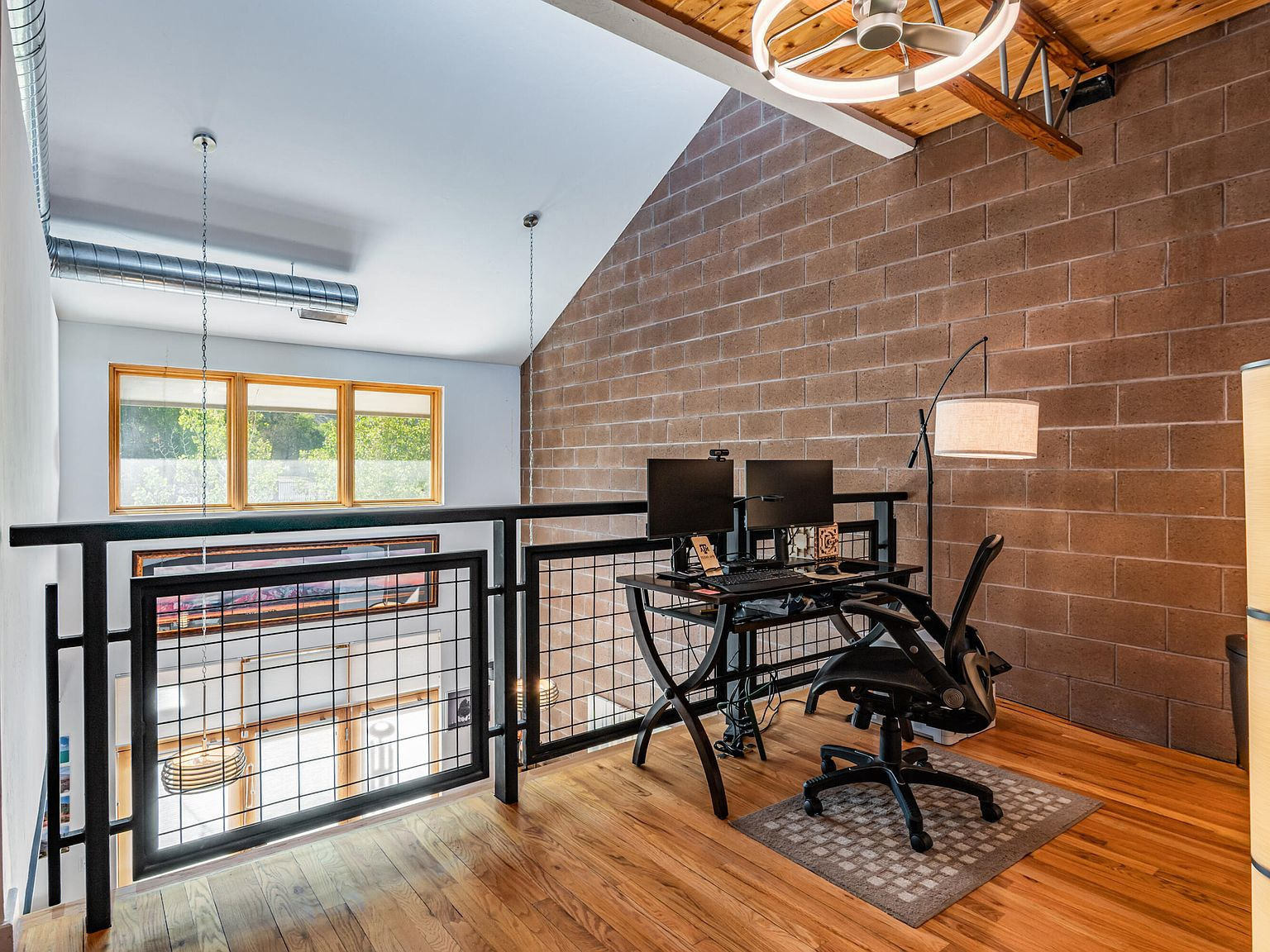 Second-floor loft office with wood plank floors and beam ceiling
