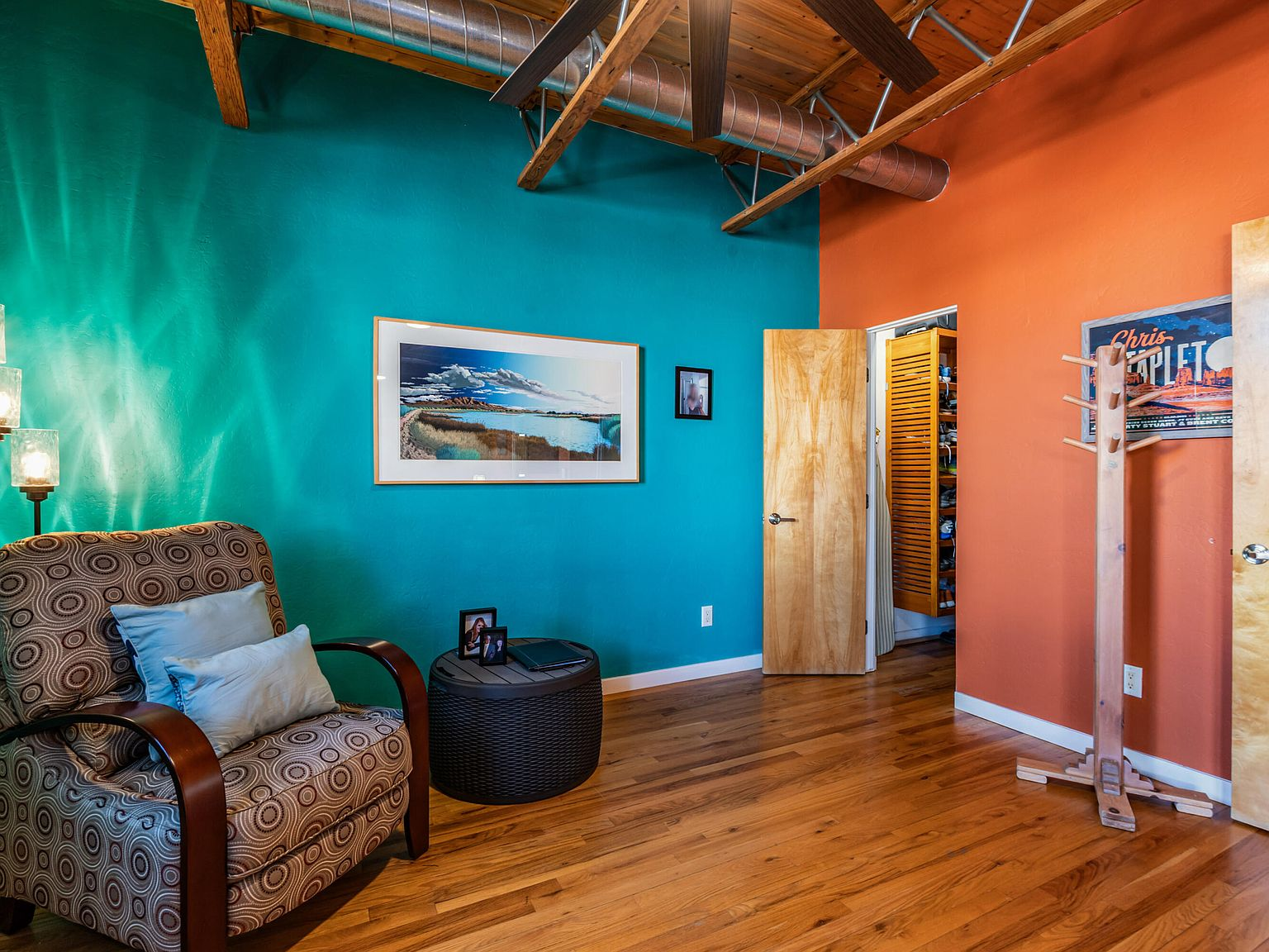 Loft sitting area with exposed wood trusses and accent walls