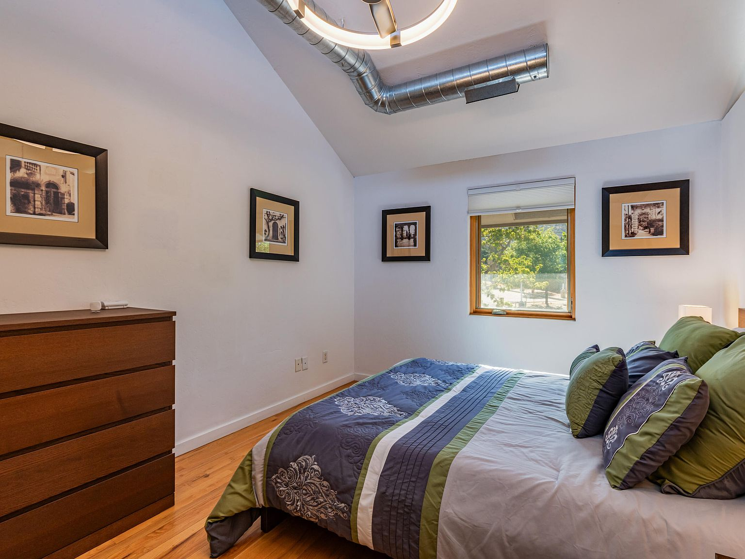 Second bedroom with vaulted ceiling and exposed ductwork