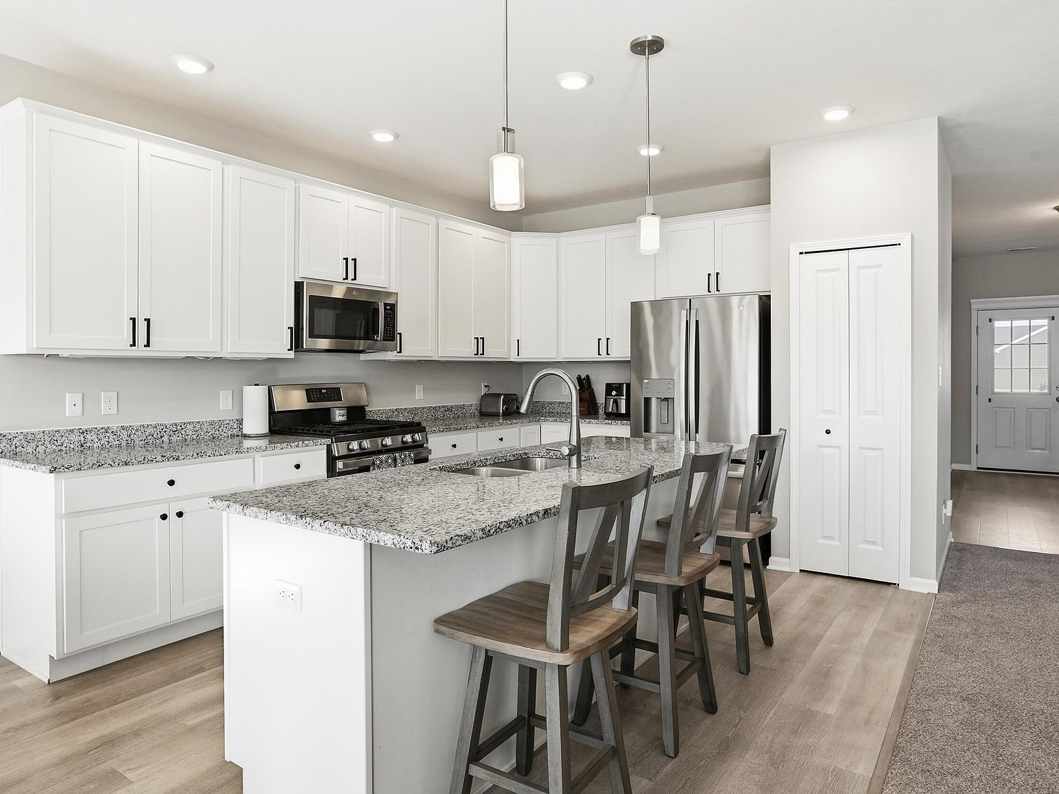 Wide-angle kitchen view with island and stainless steel appliances