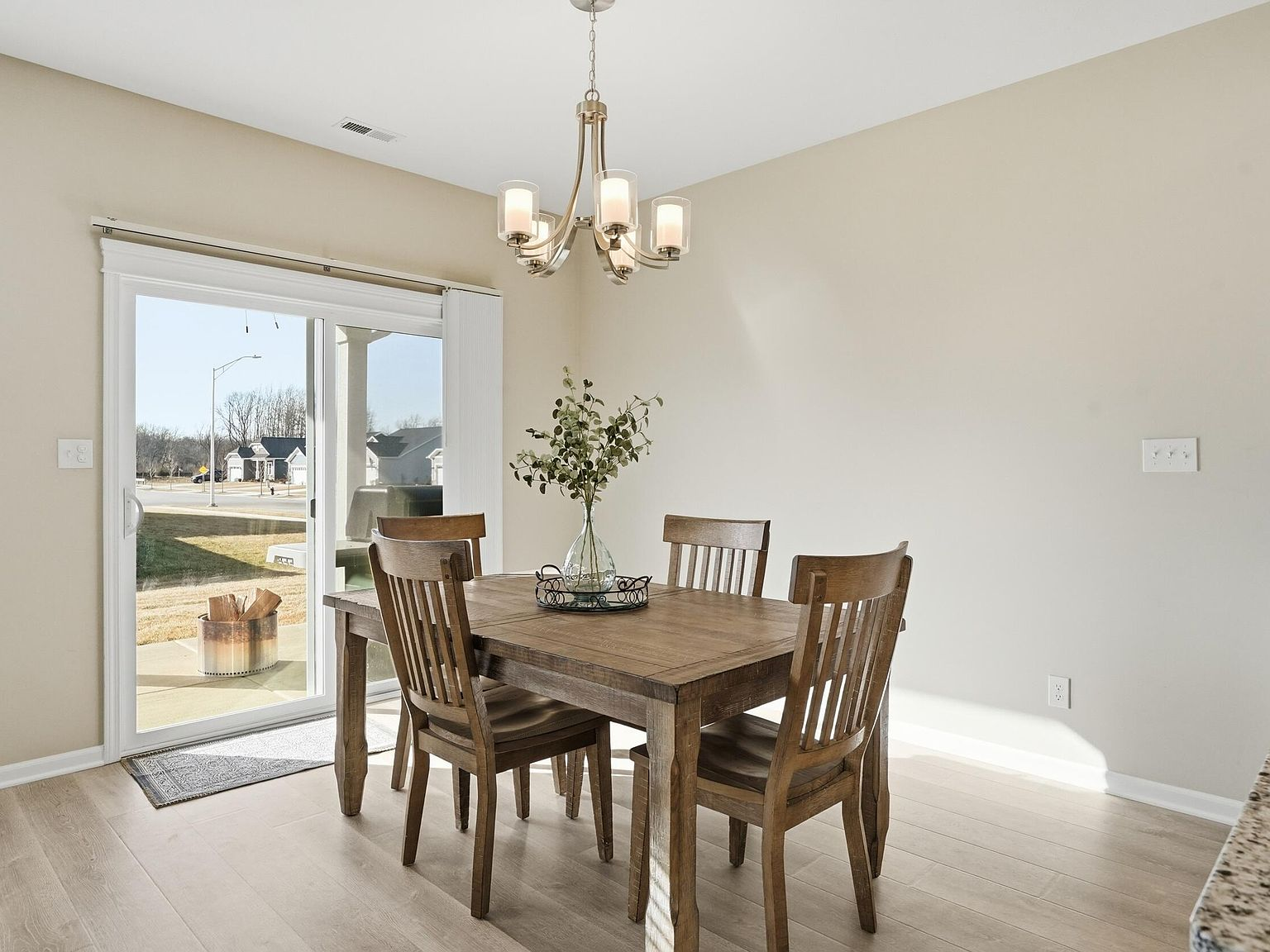 Dining area next to sliding glass door with natural light and wood laminate flooring