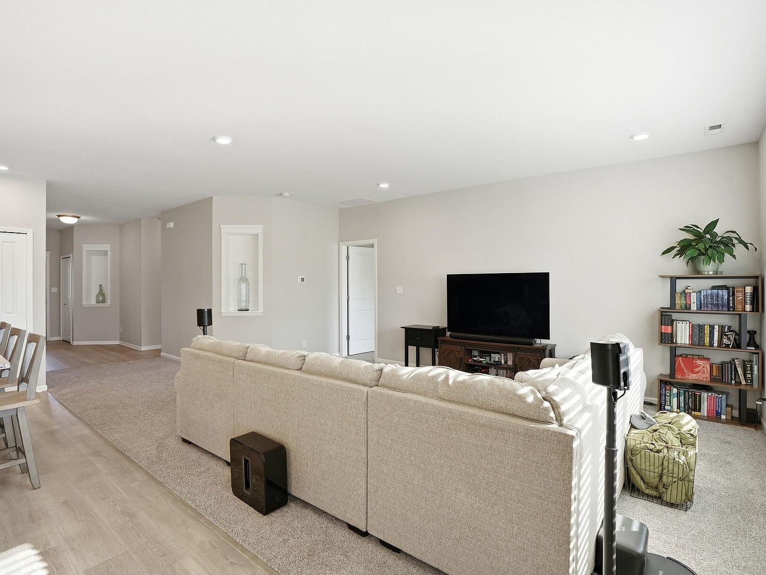 Living room with beige carpet, recessed lighting, and large windows