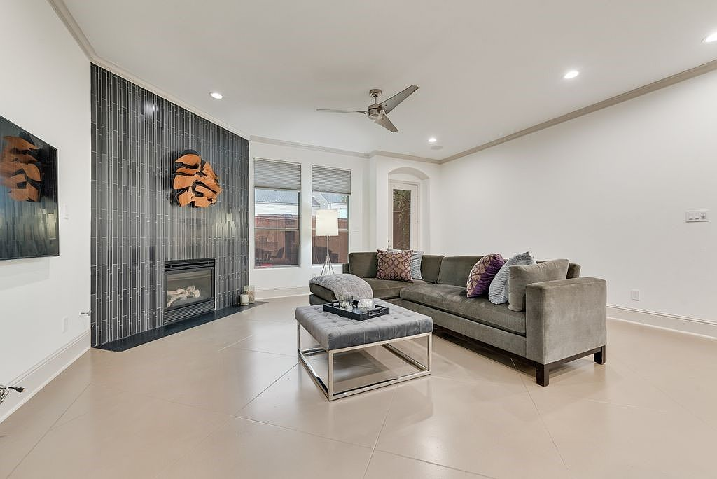 Living room with dark vertical tile fireplace surround and stained concrete floors