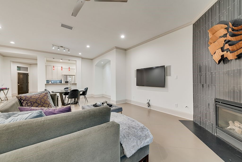 Open-concept living room looking towards the dining area with vertical tile fireplace