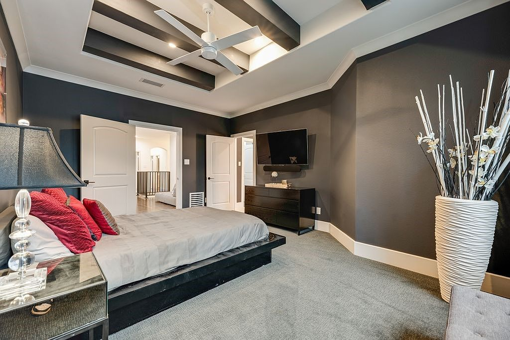 Primary bedroom wide-angle view with tray ceiling, black beams, and dark charcoal walls