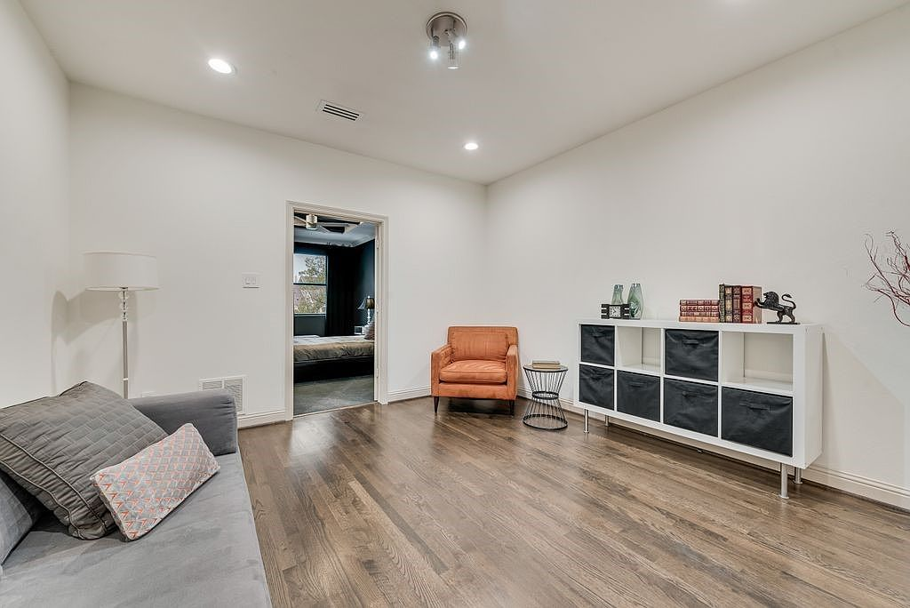 Loft flex space with dark hardwood floors and recessed lighting