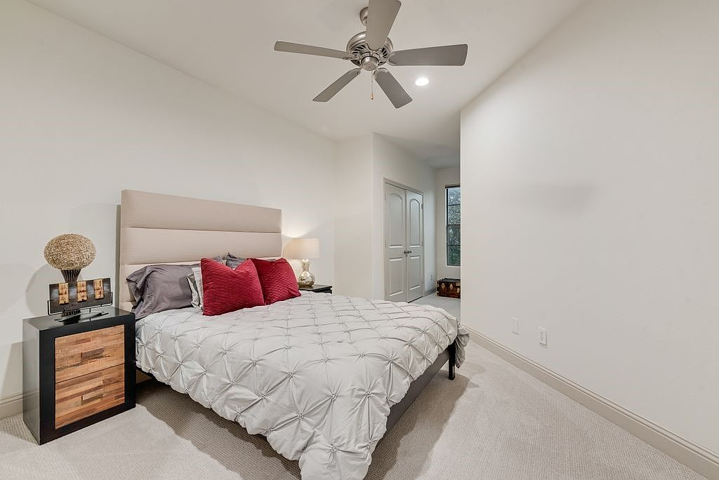 Guest bedroom with neutral walls and light-toned carpet