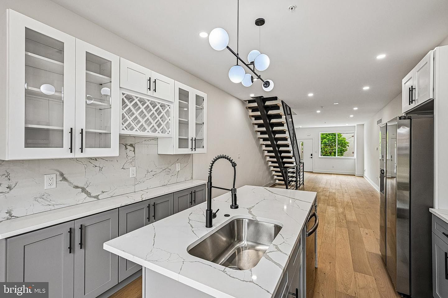 View looking out from the master-crafted kitchen towards the entry and staircase