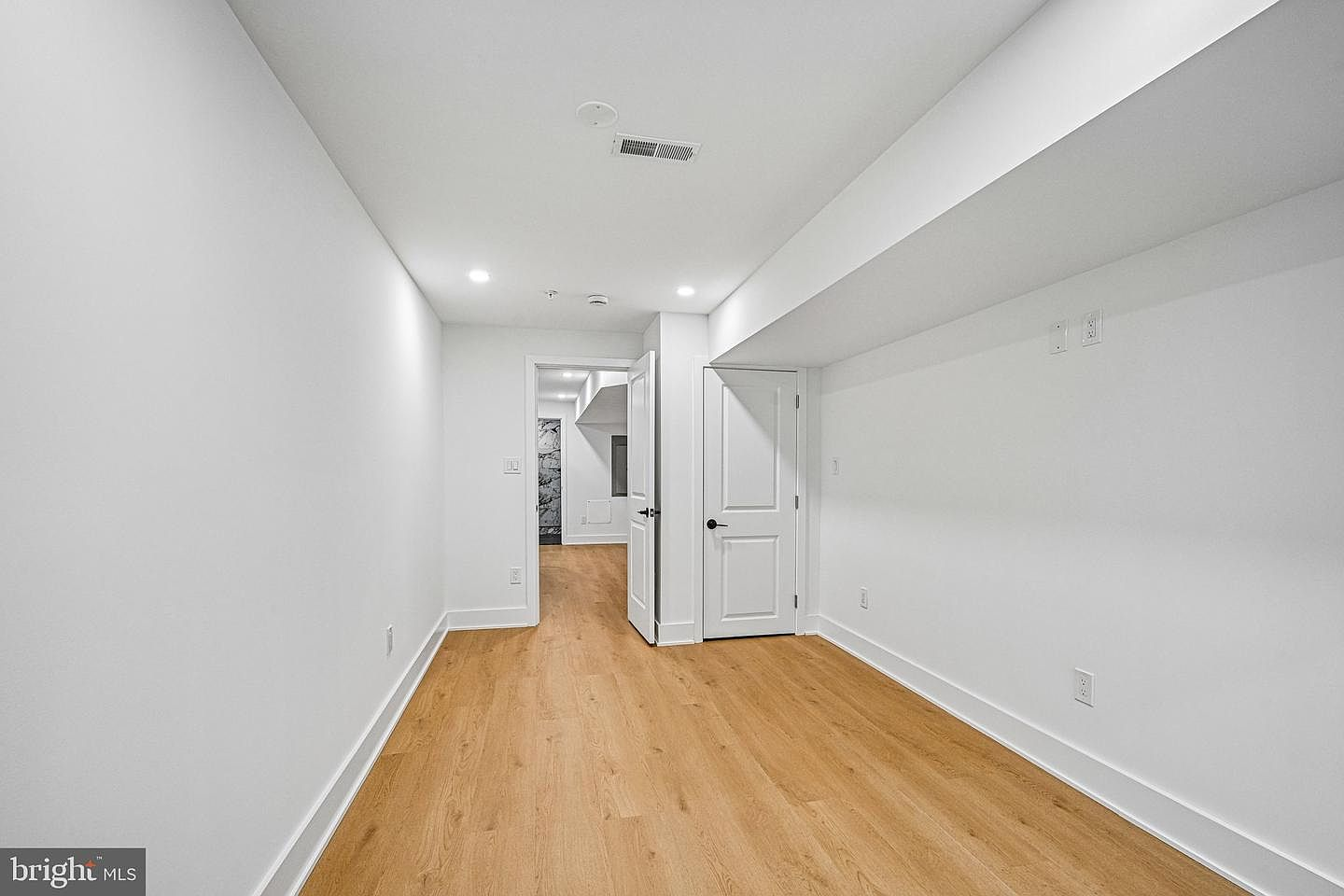 Lower floor corridor with recessed LED lighting and custom white framing panels