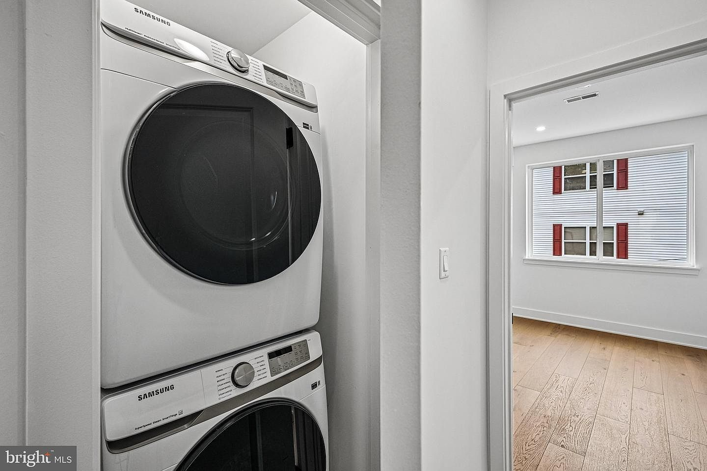 Modern designated laundry area featuring premium stacked Samsung washer and dryer