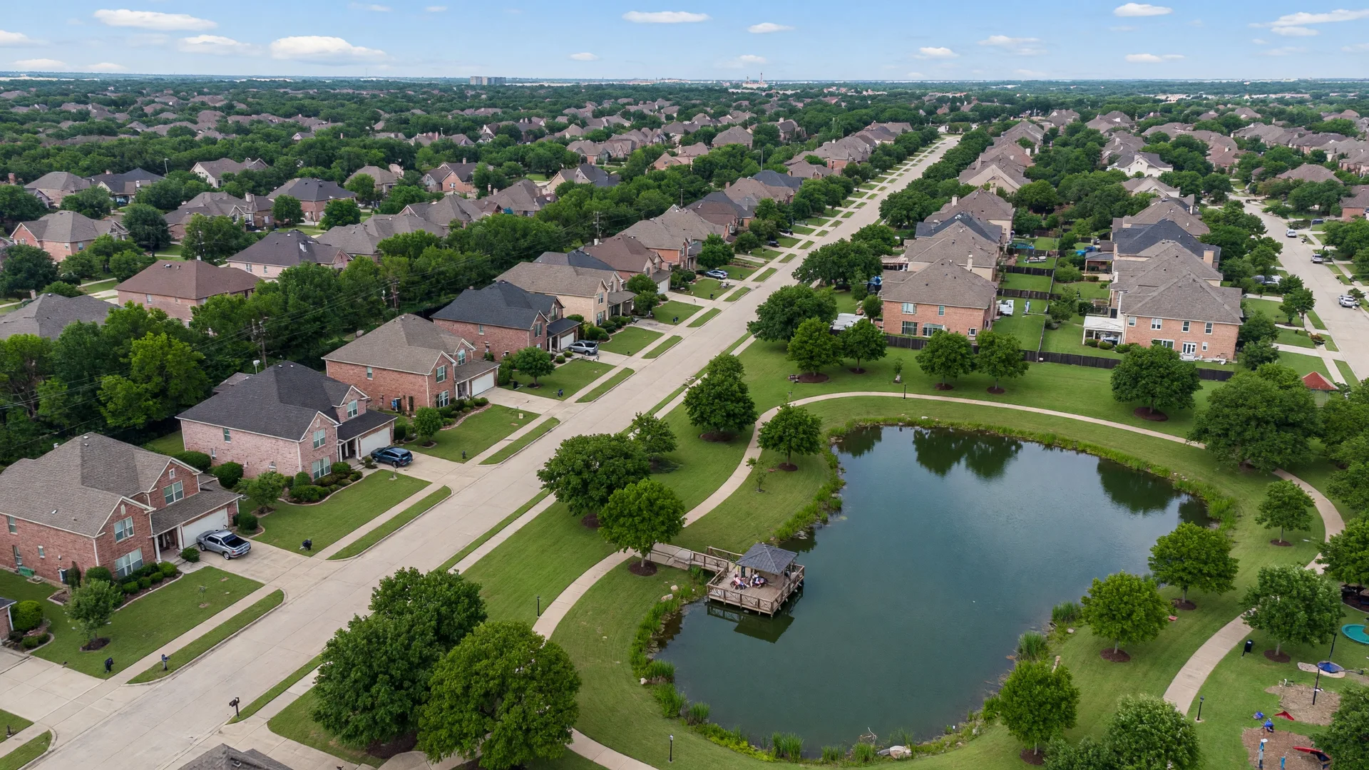 Aerial view of Sycamore Cove neighborhood with homes, tree canopy, and community green space