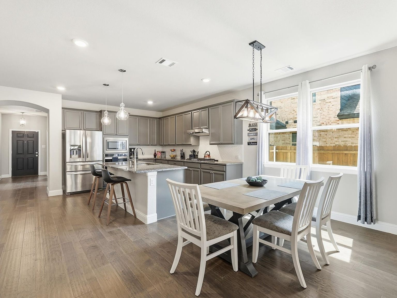 Kitchen and dining area with grey cabinets and stainless appliances