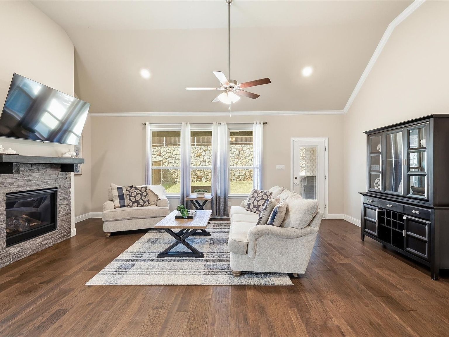 Living room with stacked-stone fireplace and vaulted ceiling