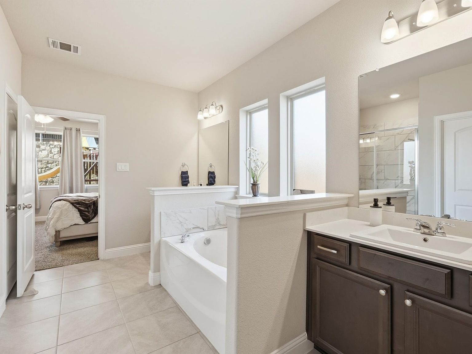 Master bathroom wide view with dual vanity and soaking tub