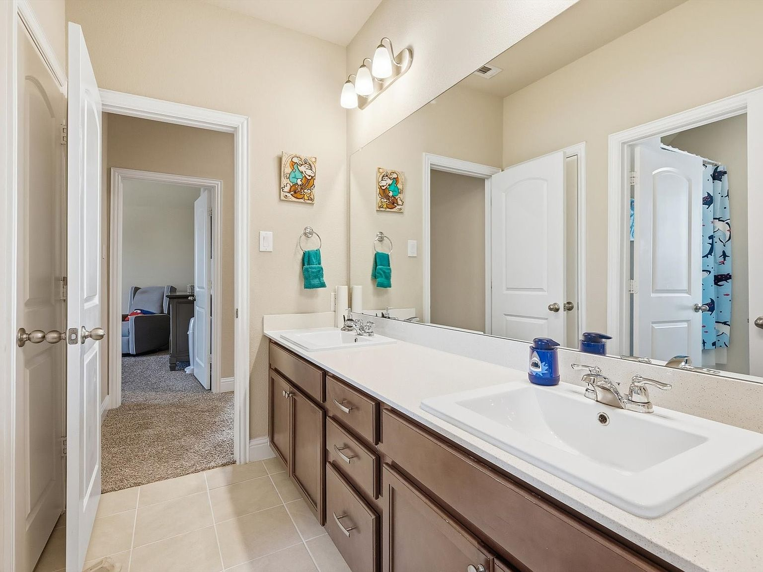 Upstairs bathroom with double vanity sinks and tile flooring