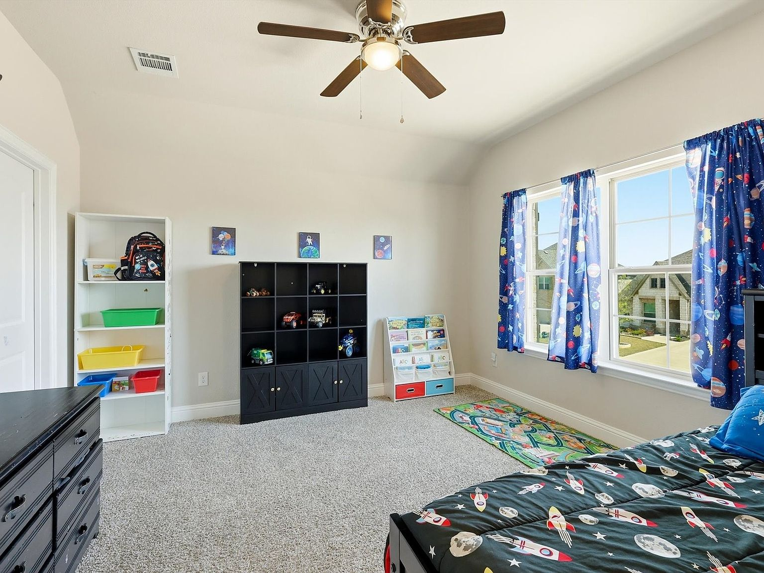 Second child bedroom with space-themed decor and blue curtains