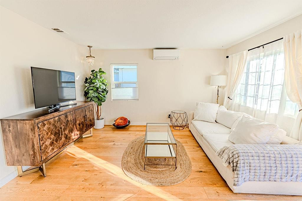 Sunlit living room with hardwood floors and coastal modern style