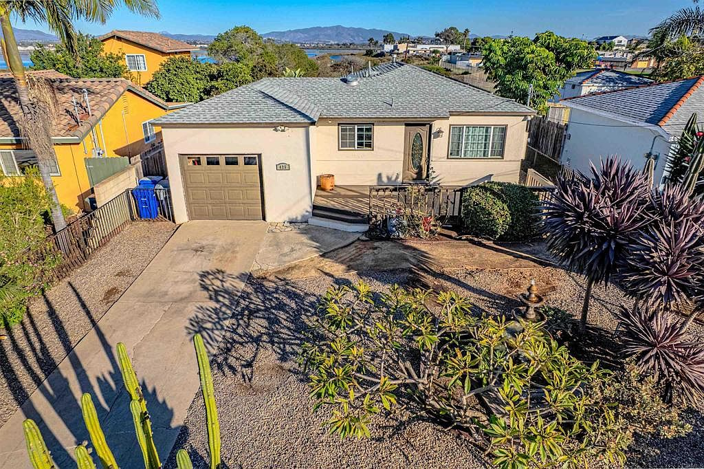 High-angle front exterior with drought-tolerant landscaping and wooden deck