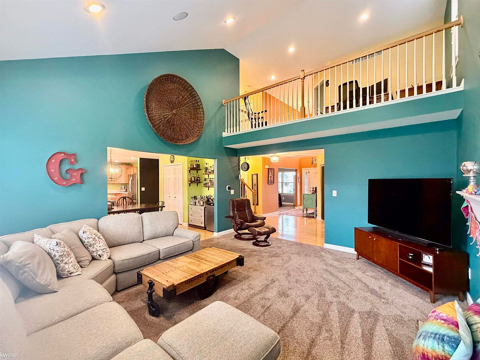 Great room with vaulted ceiling and loft railing above